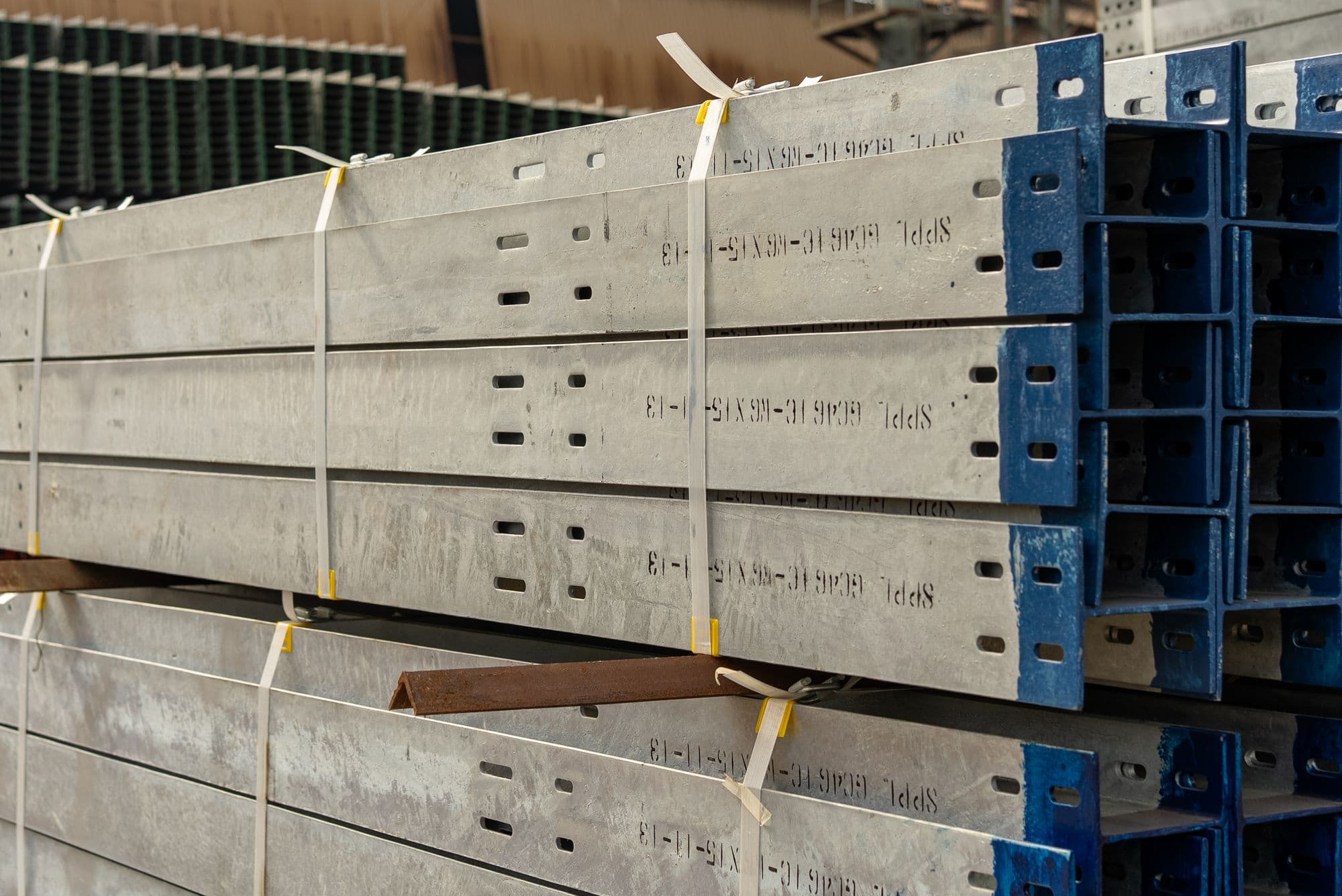 Processed structural steel members stacked in a fabrication facility