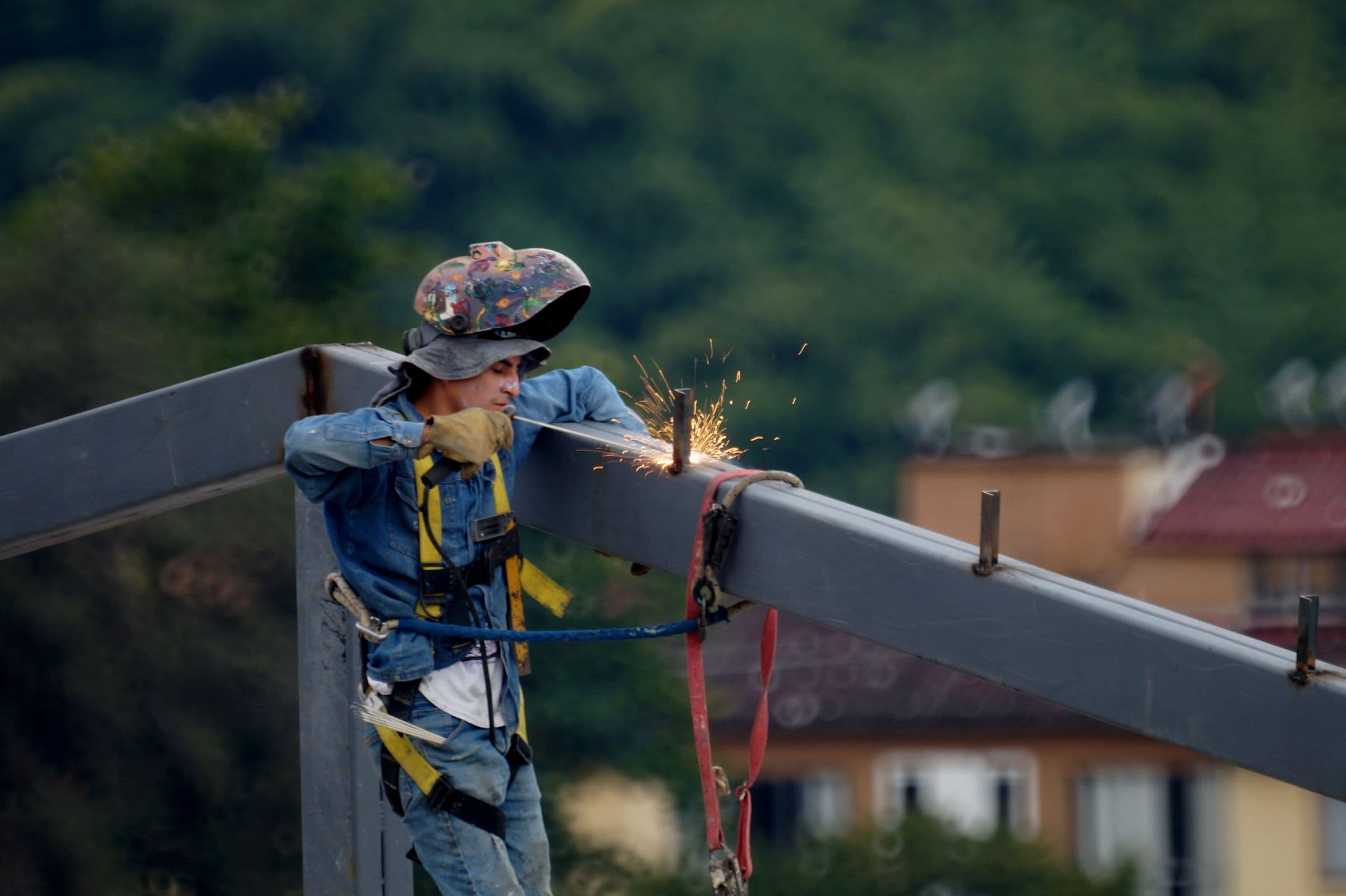 Ironworker welding a structural steel beam at height