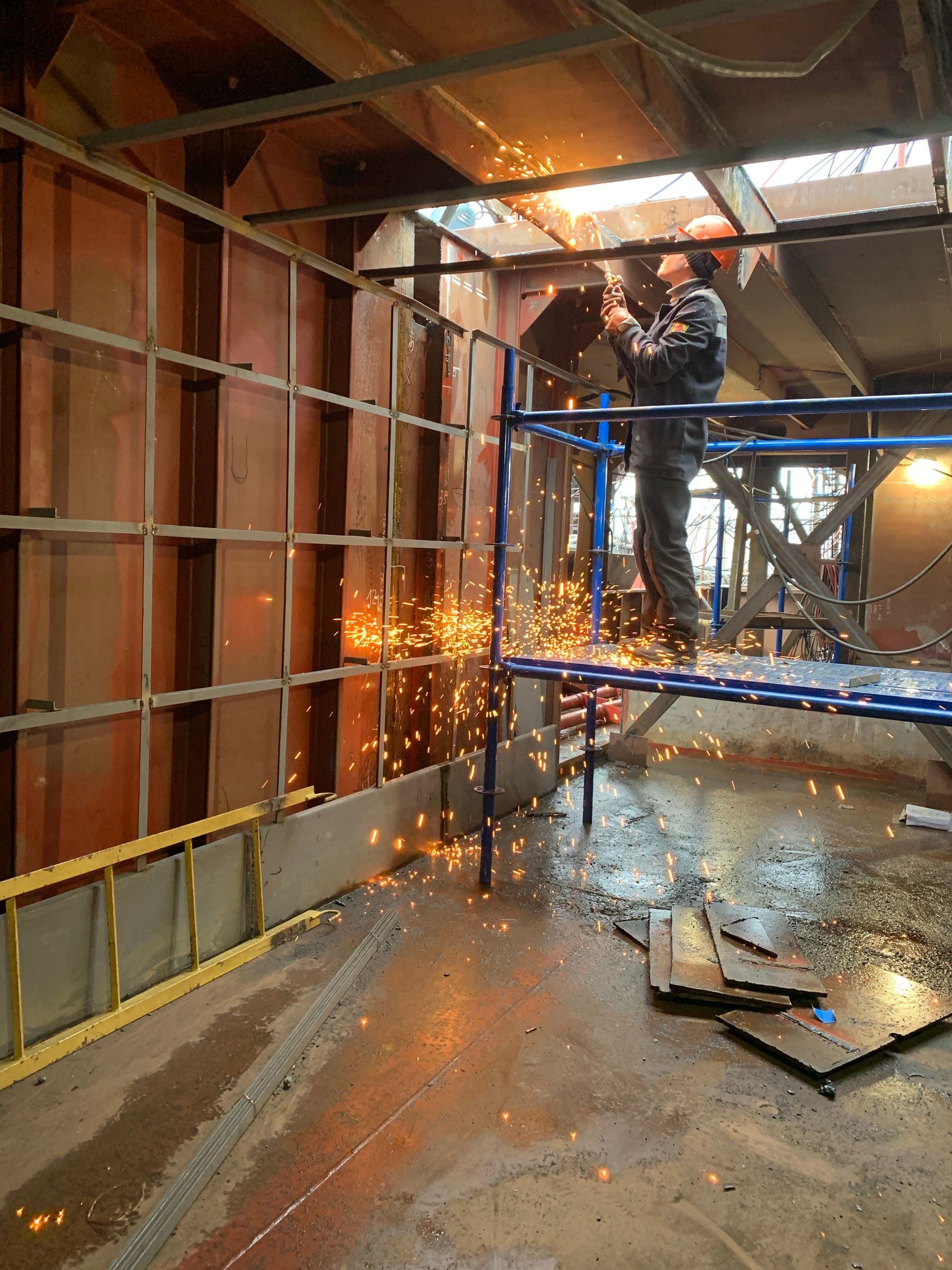Fabricator working inside a large steel assembly